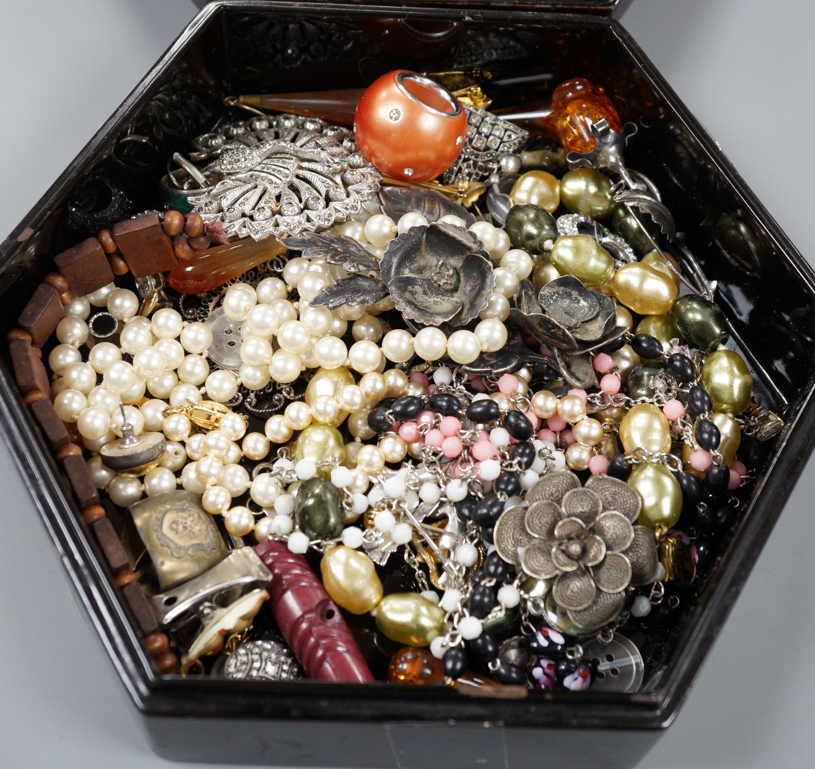 A quantity of assorted costume jewellery in a lacquer box.
